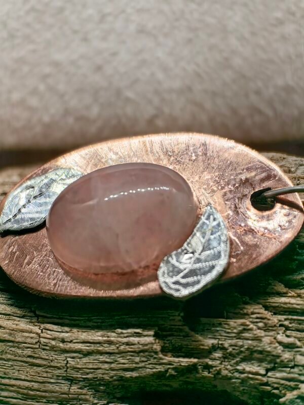 Vue latérale du pendentif Rose des Mers montrant les détails des feuilles de rose trémière en argent finement gravées à la main.