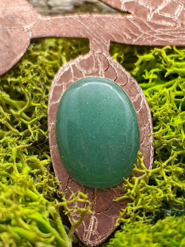 Gros plan sur l'aventurine verte sertie sur une feuille du pendentif Liseron des Dunes, symbolisant la force tranquille et la beauté