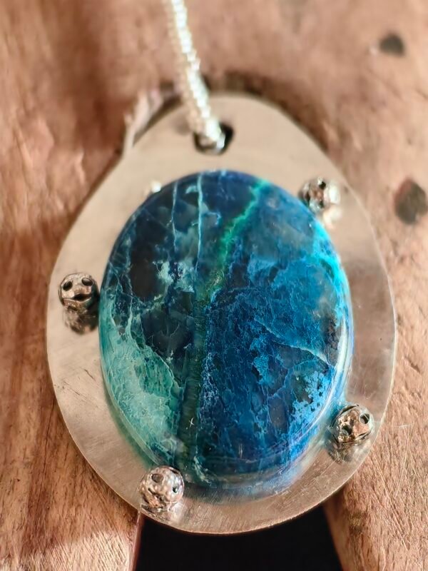 Gros plan sur la shattuckite bleue du pendentif Écho de la Mer, rappelant les lagons clairs et les abysses sombres