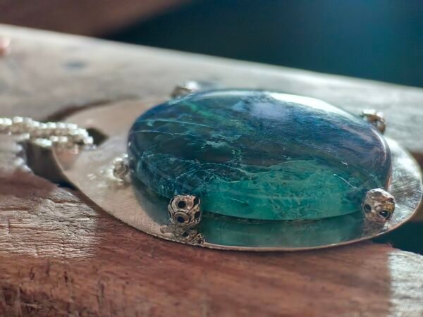 Vue latérale du pendentif Écho de la Mer montrant les détails du médaillon en argent et des perles d'argent