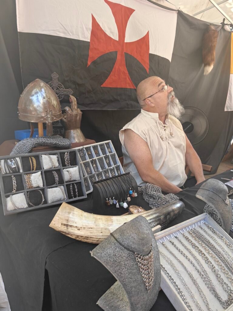 Artisan travaillant le fer afin de construire à la main anneaux après anneaux des côtes de mailles.