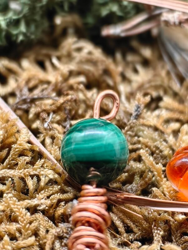 Détail de la perle de malachite sur le pendentif 'Portrait d'Automne', symbolisant l'automne