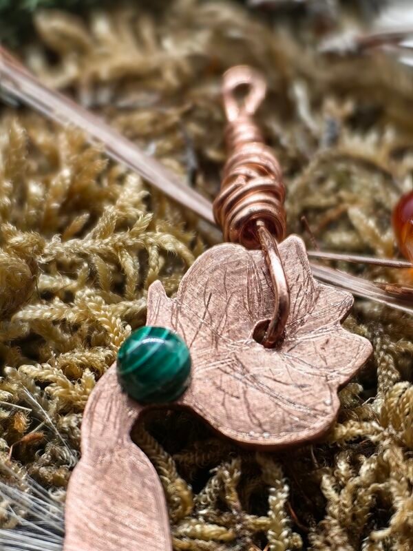 Gros plan sur le cabochon de malachite serti au centre du pendentif.