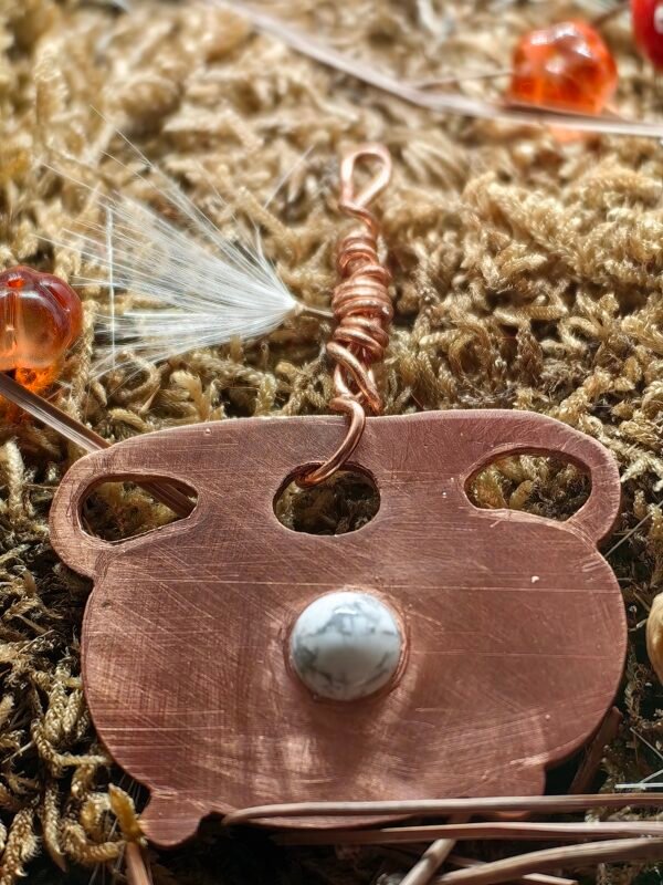 Vue avant du pendentif 'Le Médailon de Samhain' en cuivre recyclé en forme de chaudron, serti d'une howlite