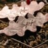 Gros plan sur la bindrune de protection, combinant les runes Othala, Thurisaz, et Algiz, sur les boucles d’oreilles.