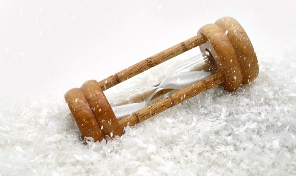 Sablier renversé dans le neige chez Le Chêne Enchanté, un symbole pour ralentir.