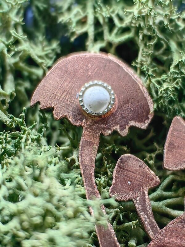 Howlite sertie en argent sur l'un des champignons du pendentif celtique.