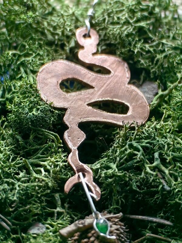 Pendentif "Le savoir du Serpent en argent et cuivre éthiques, hypoallergénique serti d'une émeraude taillée de 2 carats, fait main en France sur de la mousse végétale naturelle.