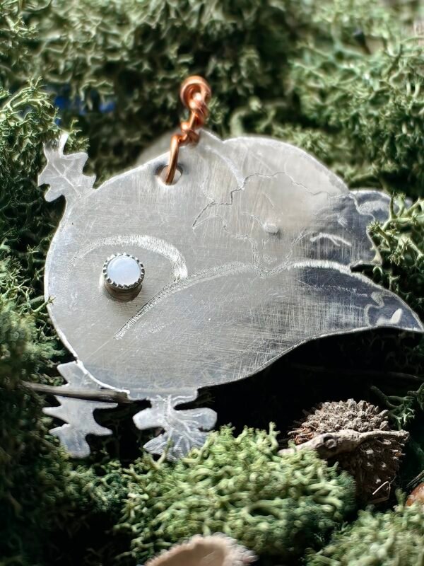 Pendentif 'Le Rusé Endormi' en argent et cuivre éthiques, fait main en France serti argent d'une calcédoine bleue, représentant un renard endormi sur un lit de fougère. Pendentif posé sur de la mousse végétale naturelle de chez Le Chêne Enchanté.