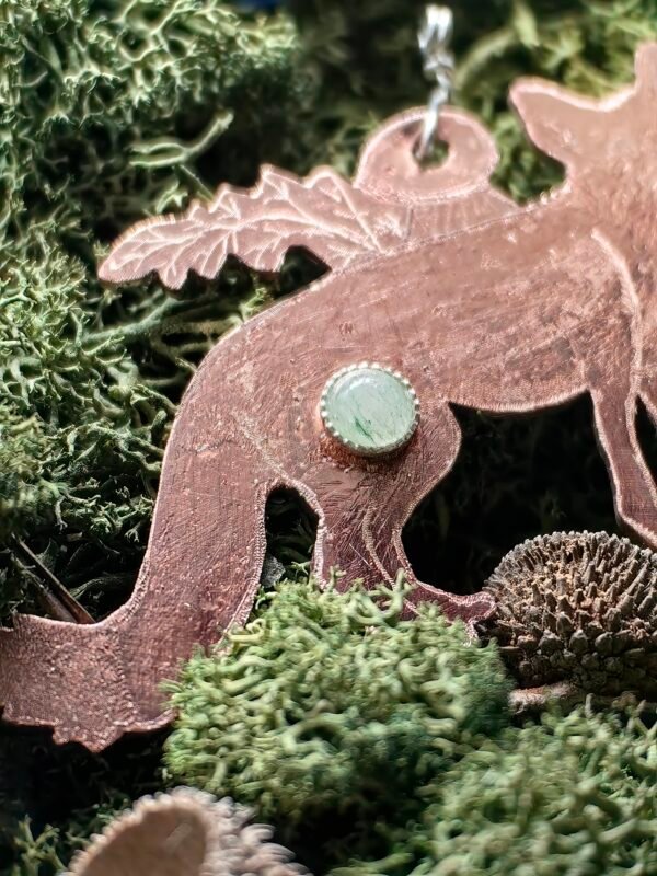 Détail du serti argent de l'aventurine verte et de la fougère et cèpe du pendentif "L'Aubrun Malicieux" en argent et cuivre éthiques, hypoallergénique, fait main en France sur de la mousse végétale naturelle de chez Le Chêne Enchanté.