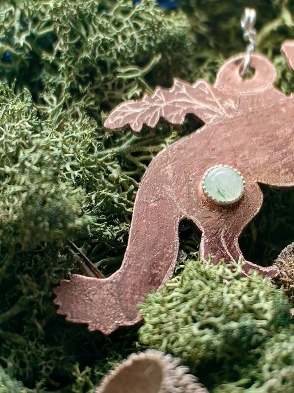 Détail du serti argent de l'aventurine verte du pendentif "L'Aubrun Malicieux" sur de la mousse végétale naturelle de chez Le Chêne Enchanté.