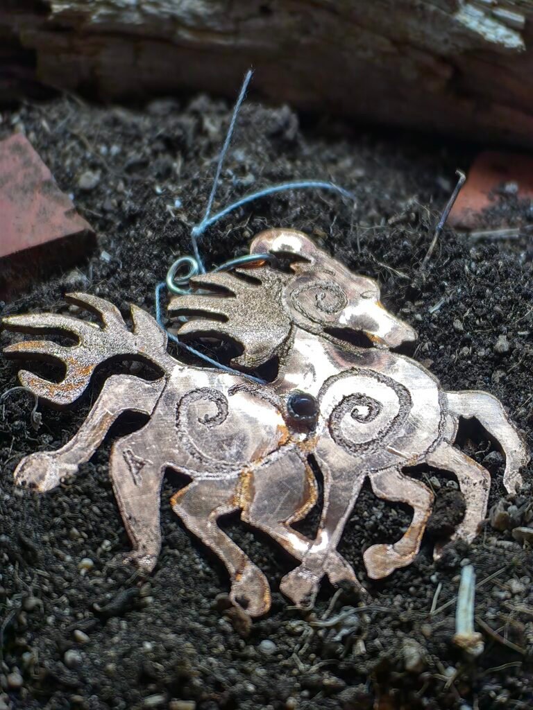 Pendentif Sleipnir, cheval à huit jambes d'Odin dans la mythologie nordique. Fait main en France dans le Sud-est de la France en argent-cuivre éthique et tourmaline noire serti clos argent. Le pendentif représente Sleipnir de profil en pleine coure la crinière au vent. Sur son corps sont gravése des runes et trois petits spirales communiquant les unes avec les autres renforçant le style Borre. Ce pendentif est un des bijoux phares de la collection Artéfacts chez Le Chêne Enchanté. Toute reproduction de mes bijoux est formellement interdite.