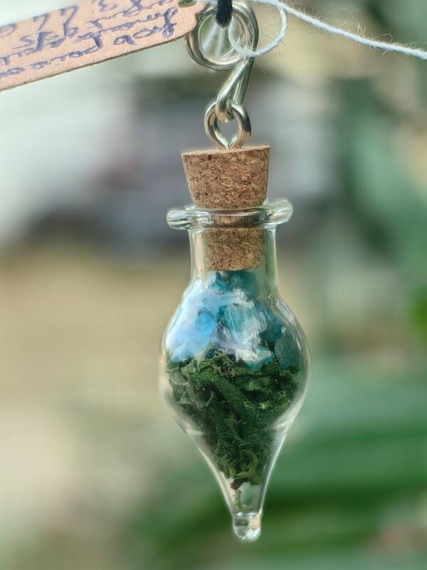 Pendentif fiole "Potion des fées" apatite et mousse végétale naturelle monté sur argent, collection Artéfacts chez Le Chêne Enchanté. Gros plan sur la fiole.