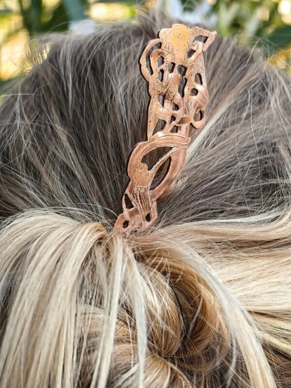 Pic à cheveux en cuivre pur "grande bête nordique" collection artéfacts chez Le Chêne Enchanté porté pour composer un chignon.