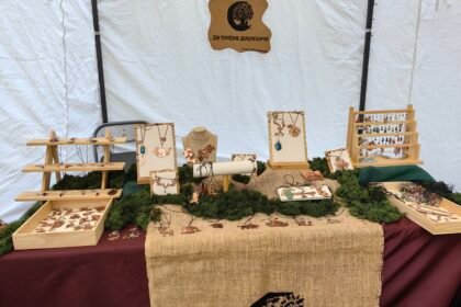 Stand de mon échoppe itinérante Le Chêne Enchanté lors d'une médiévale. Vu de près de mon stand avec ma table d'exposition contenant mes bijoux talismans-guides historiques joailliers éthiques, mon logo et le nom de mon entreprise. Crédit photo Le Chêne Enchanté, toutes reproductions de mon stand que ce soit ses couleurs, ses décorations et mes bijoux sont formellement interdites.