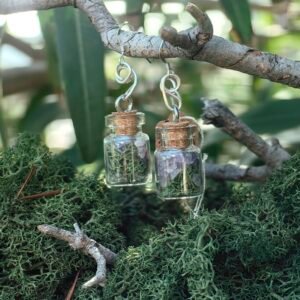 Boucles d'oreilles fiole Talisman des fées, argent, améthyste, mousse végétale naturelle, liège de chêne, collection Artéfacts chez Le Chêne Enchanté. les boucles d'oreilles sont suspendues sur une branche de chêne entouré de mousse naturelle végétal de mon jardin. Vu d'ensemble de la paire de boucles d'oreilles. Ces boucles d'oreilles sont des aurores douces enfermées dans un micro monde. Elles guident, favorisent l'intuition, le rêve et la magie. Tous les bijoux et photographies appartiennent exclusivement à : Le Chêne Enchanté. Toute reproduction est strictement interdite.